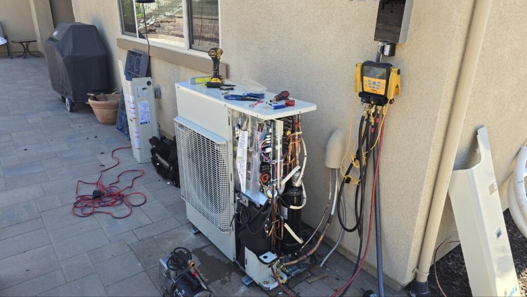 Levano Pro HVAC technician charging a newly installed heat pump outdoor unit with gauges connected on a Sacramento-area patio
