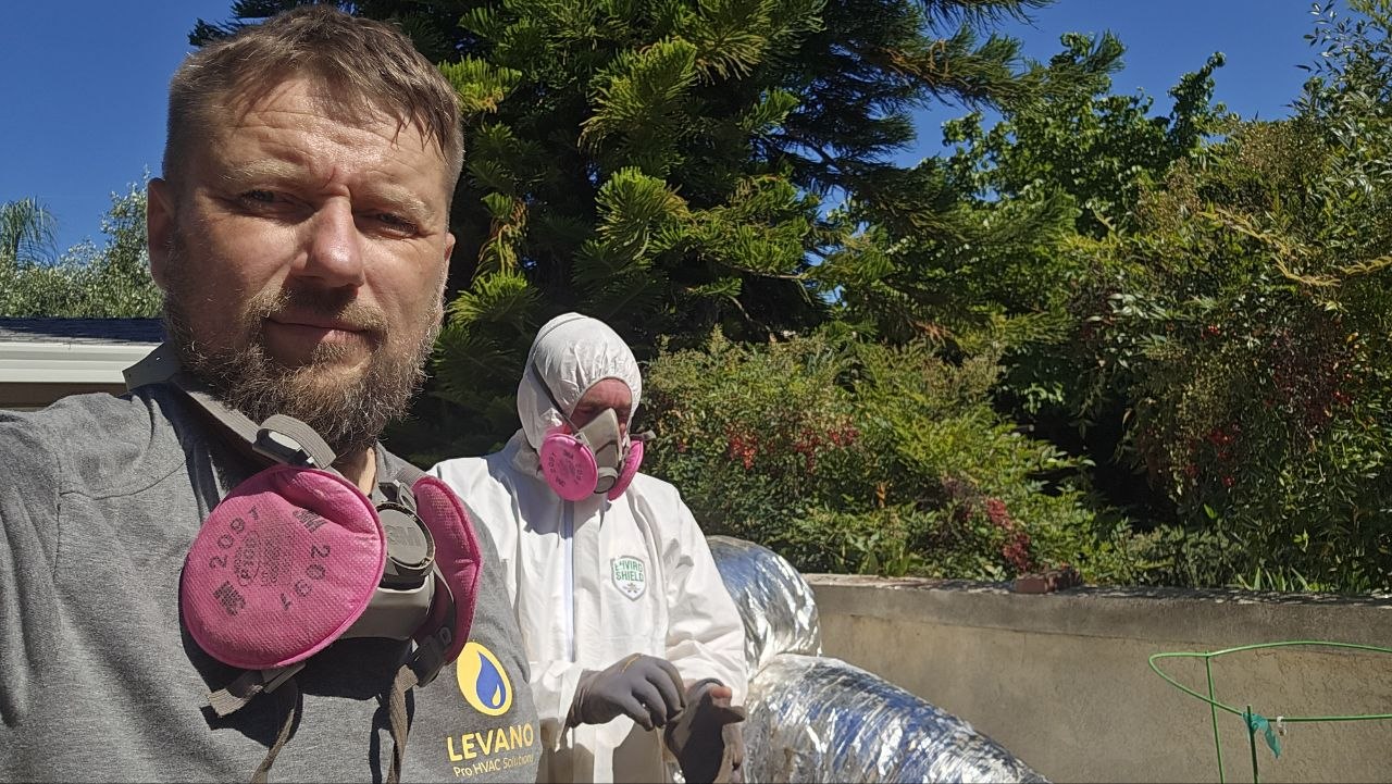 Levano Pro HVAC technicians wearing respirators before opening a furnace cabinet on a service call