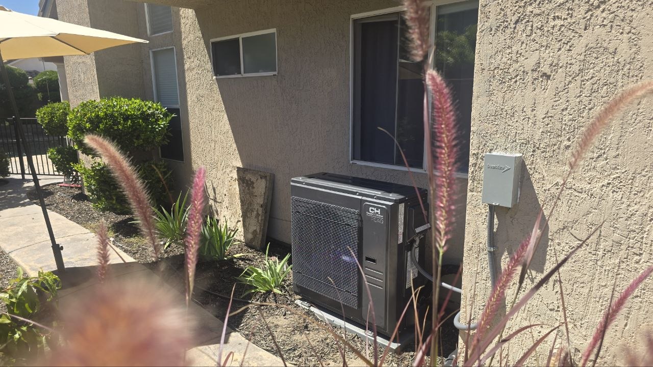 Cooper and Hunter ductless mini-split outdoor unit installed on a concrete pad beside a stucco home in the Sacramento area