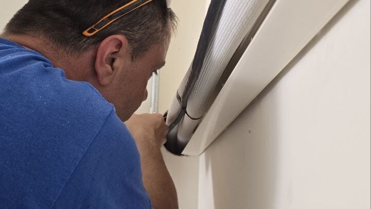 Levano Pro HVAC technician checking the line set and condensate path where a ductless unit enters the wall