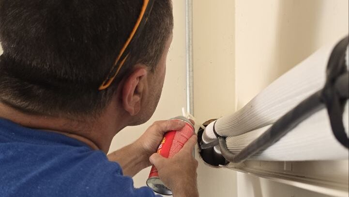 Levano Pro HVAC technician sealing the wall penetration for a ductless mini-split line set