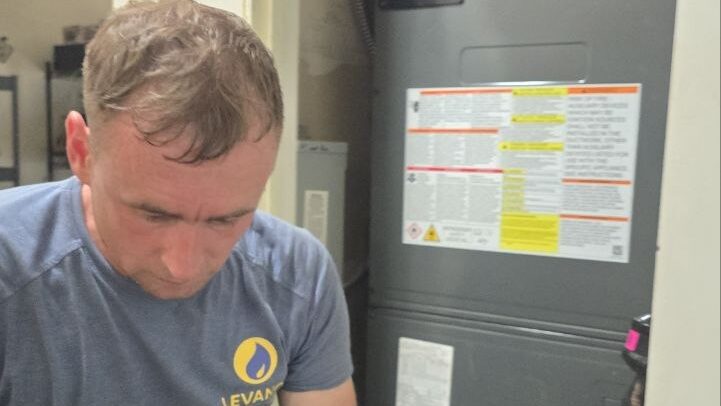 Levano Pro HVAC technician checking the connections at an indoor air handler