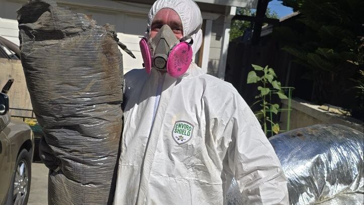 Levano Pro HVAC technician in protective gear removing old, contaminated flex duct