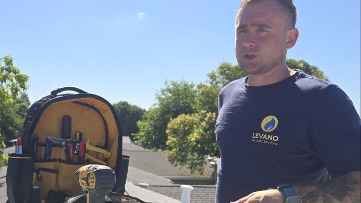 Levano Pro HVAC technician on a residential roof next to a package air conditioning unit