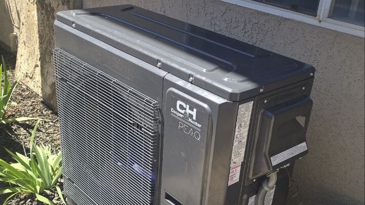 Cooper and Hunter heat pump outdoor unit beside a stucco home in the Sacramento area