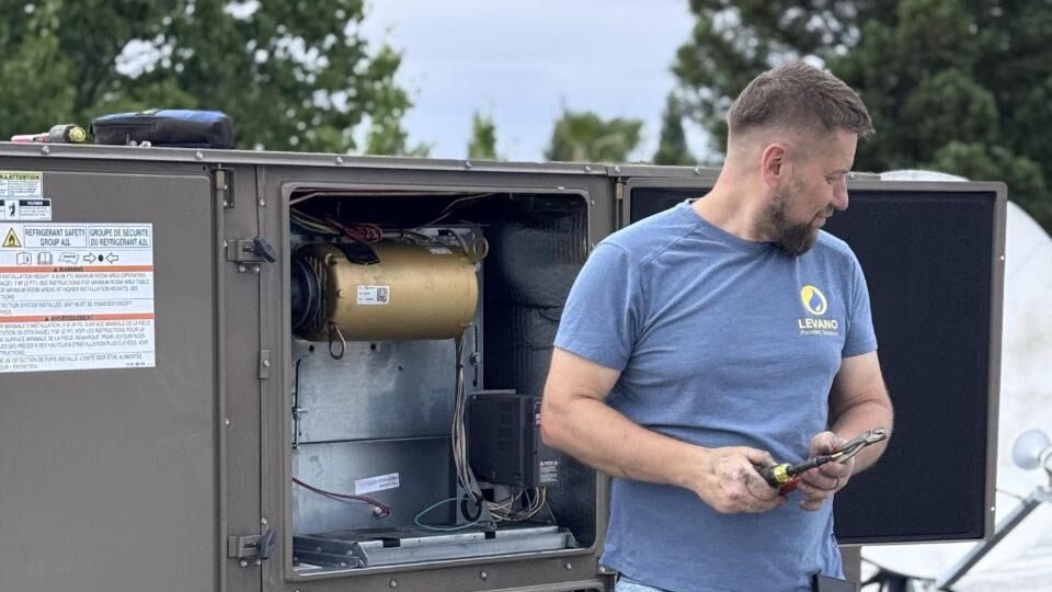 Levano Pro HVAC technician performing a seasonal maintenance check on an outdoor AC unit